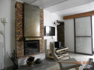 a living room with a fireplace and a tv at Domaine de Pré Rond in La Faurie