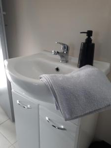 a white bathroom sink with a towel on it at Cozy Town Center Retreat in Komárno