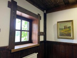 a window in the corner of a room with wooden walls at Senasis Rambynas in Lumpėnai