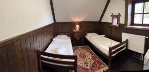 Habitación pequeña con 2 camas y mesa. en Senasis Rambynas en Lumpėnai