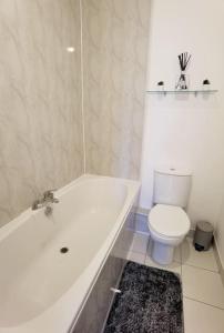 a bathroom with a white tub and a toilet at Spacious 2 Bedroom Apartment, 3 Bathrooms,Parking,Sleeps 6,SO15 in Southampton