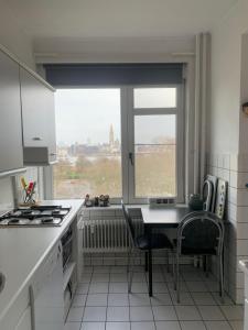 cocina con mesa, sillas y ventana en Apartment Linkerover- City Centre & Cathedral view en Amberes