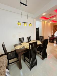 a dining room with a wooden table and chairs at Matheera Holiday Home in Jaffna