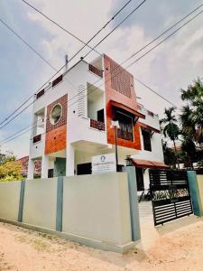 een wit gebouw met een hek ervoor bij Matheera Holiday Home in Jaffna