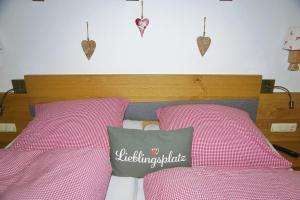 1 dormitorio con 2 camas rosas con corazones en la pared en Ferienwohnung Johannesklause, en Mittenwald