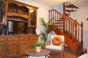una sala de estar con un gran centro de entretenimiento de madera con TV en Casa Merino, en Mioño