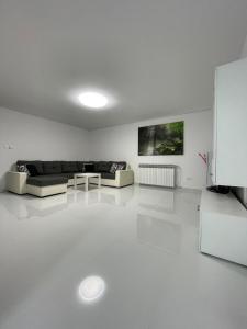 a white living room with a couch and a table at Apartment White Zagreb - private parking&garage in Zagreb