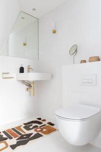 a bathroom with a toilet and a sink and a rug at Luxury 2 Bedroom Duplex Holborn London in London