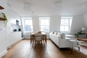 un soggiorno con divano e tavolo di Luxury 2 Bedroom Duplex Holborn London a Londra