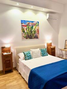 una camera da letto con un letto con lenzuola blu e un dipinto di Qurchiti a Capo dʼOrlando