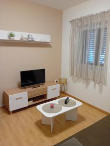 a living room with a tv and a coffee table at Apartman Krčina in Krnica
