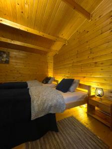 sypialnia z łóżkiem w drewnianym domku w obiekcie DOMKI LETNISKOWE KOMAŃCZA w Komańczy