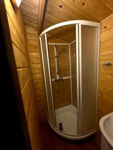 y baño de madera con ducha y bañera. en DOMKI LETNISKOWE KOMAŃCZA, en Komańcza