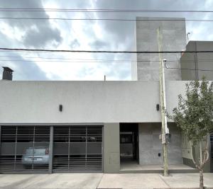 a building with a garage with a car parked in it at Departamento en complejo semiprivado con cochera in Guaymallen