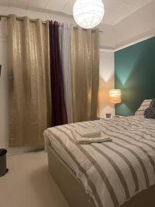 a bedroom with a bed and a lamp and curtains at Private Room 1 Near Southmead Hospital, Bristol in Bristol