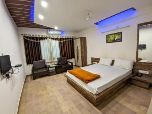 Schlafzimmer mit einem Bett, einem Schreibtisch und einem TV in der Unterkunft KRL Inn in Mandvi