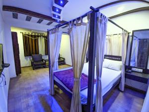 1 dormitorio con cama con dosel y sábanas moradas en KRL Inn en Mandvi