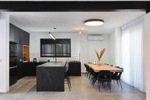 a kitchen and dining room with a table and chairs at וילה אליה in Migdal