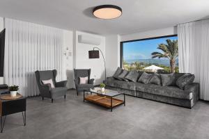 a living room with a couch and two chairs at וילה אליה in Migdal