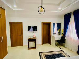 a room with a bed and a desk and a table at Abuja Getaways in Abuja