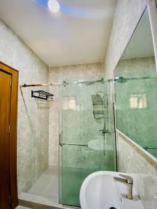 a bathroom with a glass shower and a sink at Abuja Getaways in Abuja