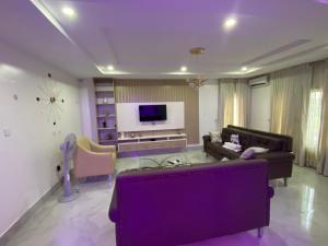 a living room with a couch and a tv at Abuja Getaways in Abuja