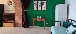 Sala de estar verde con sofá y TV en Apartments Tinjarosa, en Mundanije