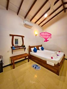 a bedroom with two beds and a pink chandelier at Wild Horizon in Udawalawe