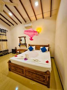 a bedroom with a large bed with a pink chandelier at Wild Horizon in Udawalawe
