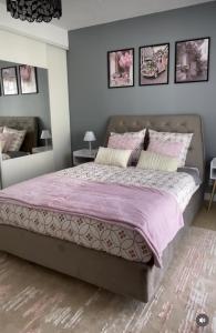 a bedroom with a large bed with pink sheets at Villa Sara in Zarzis