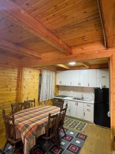 ein Esszimmer mit einem Tisch und einer Küche in der Unterkunft Vila Kanadeze in Koplik