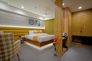 a bedroom with a bed and a couch and a tv at Hotel Lake Point in Ahmedabad