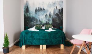 a room with a green table with two swans on it at Całorocznik apartamenty in Ryczów