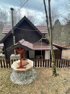 ein Haus mit einem Dach mit einem Holzständer davor in der Unterkunft Vila Kanadeze in Koplik
