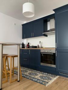 a kitchen with blue cabinets and a table at ROST room in Oradea