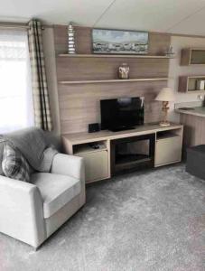 a living room with a couch and a flat screen tv at Immaculate 2020 Caravan on Newquay Holiday Park in Newquay