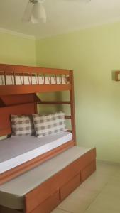um quarto com um beliche de madeira com almofadas em Estrela de Iguaba em Iguaba Grande