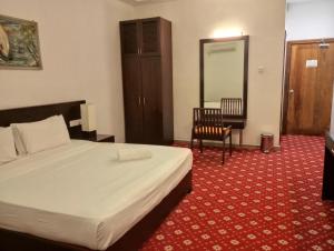 a hotel room with a bed and a chair at Ramadia Ran Mal Holiday Resort in Moratuwa