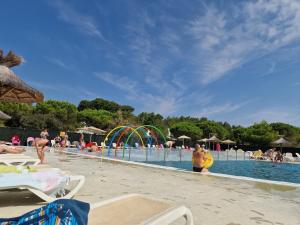 een zwembad met mensen die in het water spelen bij Mobilhome Clim Télé La Falaise 4 étoiles in Narbonne