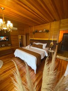 um quarto com uma cama grande num quarto de madeira em Refúgio Romântico com jacuzzi e café da manhã em Rancho Queimado em Rancho Queimado