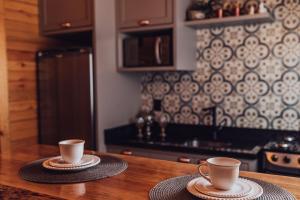 two coffee cups sitting on top of a kitchen counter at Romantic Getaway with Jacuzzi and Breakfast in Rancho Queimado in Rancho Queimado