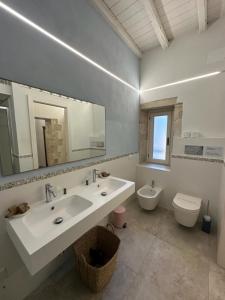 a bathroom with a sink and a toilet and a mirror at Archè in Syracuse