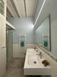 a white bathroom with a sink and a mirror at Archè in Syracuse