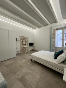 a large white bedroom with a bed and a fireplace at Archè in Syracuse