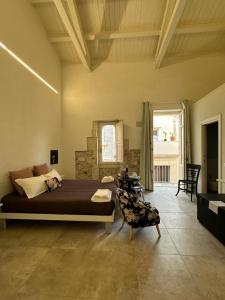 een slaapkamer met een bed en een stoel in een kamer bij Archè in Siracusa