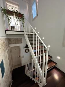 a white staircase with a white railing and a window at Archè in Syracuse