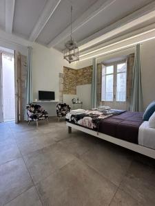 a bedroom with a large bed and a living room at Archè in Siracusa