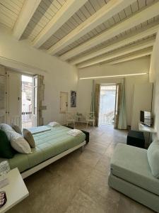 ein großes Schlafzimmer mit einem Bett und einem Sofa in der Unterkunft Archè in Syrakus