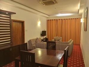 a living room with a wooden table and chairs at Ramadia Ran Mal Holiday Resort in Moratuwa