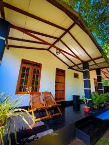 a house with two chairs and a patio at Wild Horizon in Udawalawe